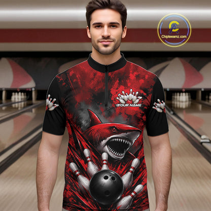 Man wearing a red and black bowling shirt with a shark design in a bowling alley.