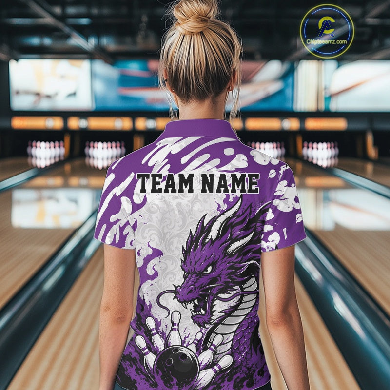 Person wearing a purple bowling shirt with a dragon design in a bowling alley.