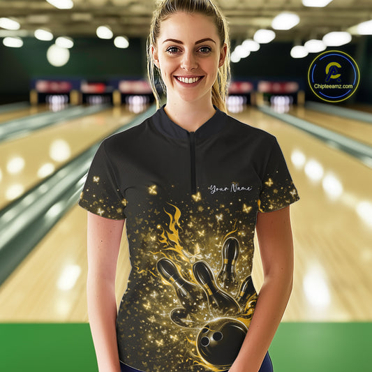 Female model wearing a black and yellow bowling quarter-zip shirt at the bowling lane with flaming bowling strike artwork and sparkly butterflies.