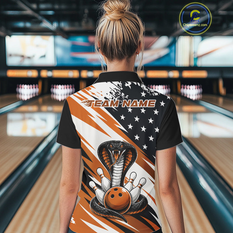Back view of a woman in a bowling alley wearing a black, white, and orange american flag cobra-themed shirt with “Team Name” across the shoulders.
