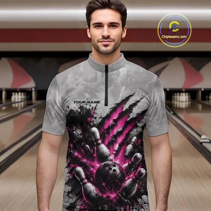Front view of a male model wearing a gray bowling quarter zip shirt featuring a dramatic pink bowling ball and pins graphic with claw-mark artwork in a bowling lane.
