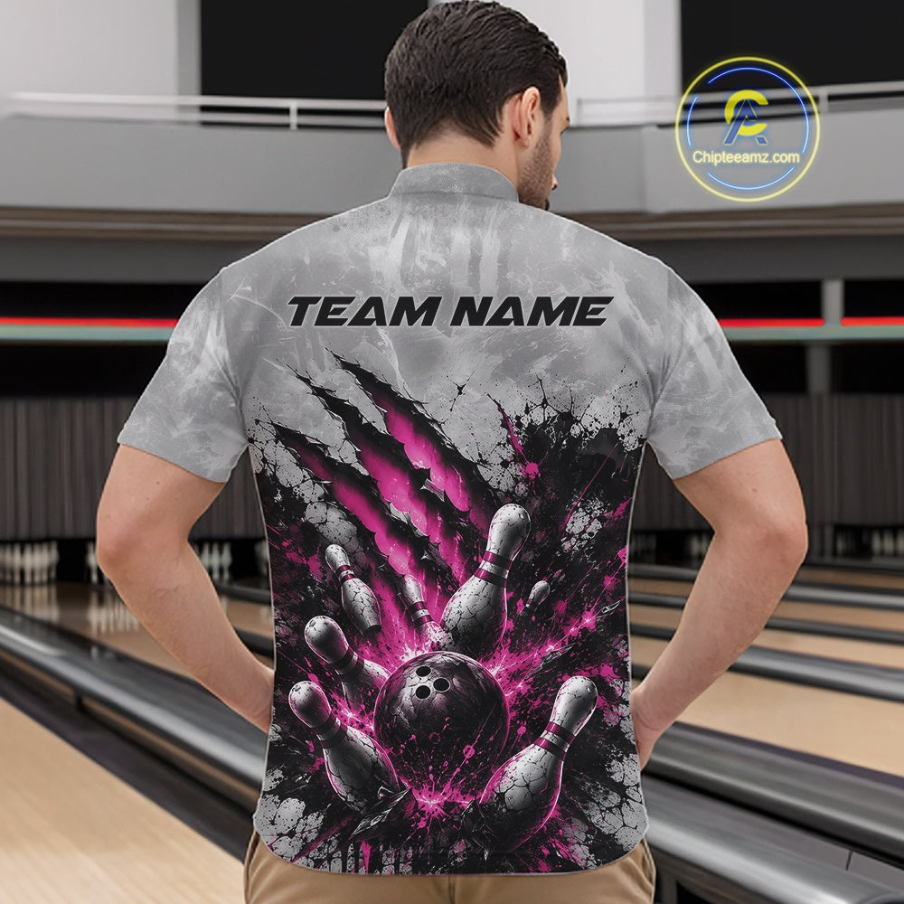 Front view of a male model wearing a gray bowling quarter zip shirt featuring a dramatic pink bowling ball and pins graphic with bold claw-mark artwork in a bowling lane.