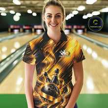 Load image into Gallery viewer, Front view of a female model wearing a bowling polo shirt showcasing a black and gold bowling ball hitting the pins graphic with flowing metallic ribbon accents in a bowling lane.