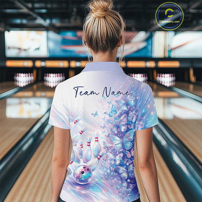 Female model in a bowling quarter zip with pastel purple and pink holographic butterfly artwork and bowling graphics, back view inside a bowling alley