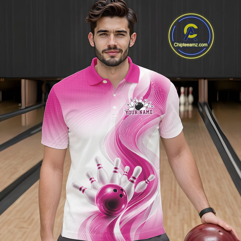 Male model wearing a white and pink bowling polo shirt with flowing abstract wave graphics and a glossy bowling ball striking pins at the bowling lane, front view