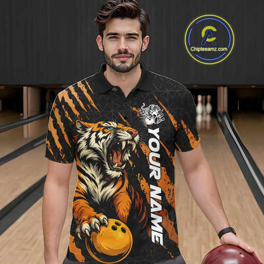 Male model wearing a black and yellow bowling polo shirt at a bowling lane, showcasing a roaring tiger holding a yellow bowling ball with orange claw-stripe graphics and a geometric background pattern.