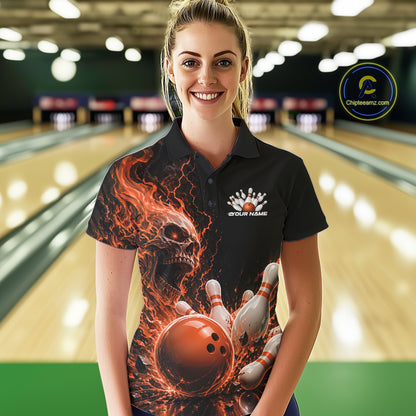 Front view of a female model in a bowling alley wearing a black bowling polo with an orange flaming skull, lightning, bowling pins, and a custom name.
