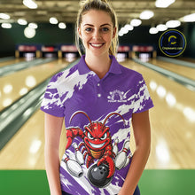Load image into Gallery viewer, Front view of a female model in a bowling alley wearing a purple custom bowling polo shirt with a fierce yet funny crawfish bowling character and a distressed background design.