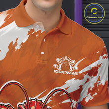 Load image into Gallery viewer, Close up front view of the left chest area on an orange custom bowling polo shirt featuring a fierce yet funny crawfish bowling character and a distressed background design.