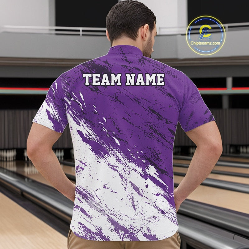 Man wearing a purple and white bowling shirt with 'TEAM NAME' on the back, standing in a bowling alley.