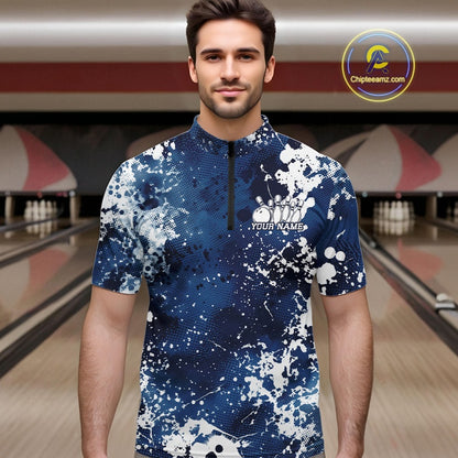 Man wearing a blue and white patterned shirt with a bowling alley in the background