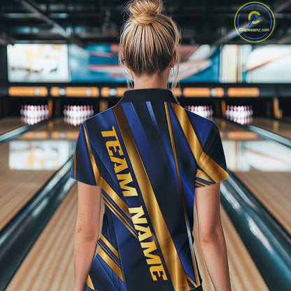 A woman viewed from behind wearing a short-sleeve bowling shirt with a navy and gold diagonal stripe pattern and the text 'TEAM NAME' printed vertically on the back. The background shows a blurred bowling alley with lanes and pins.