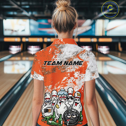 Back view female model at bowling lane wearing white polo with orange and white grunge splatter, cartoon bowling pins and bowling ball surrounded by beer bottles