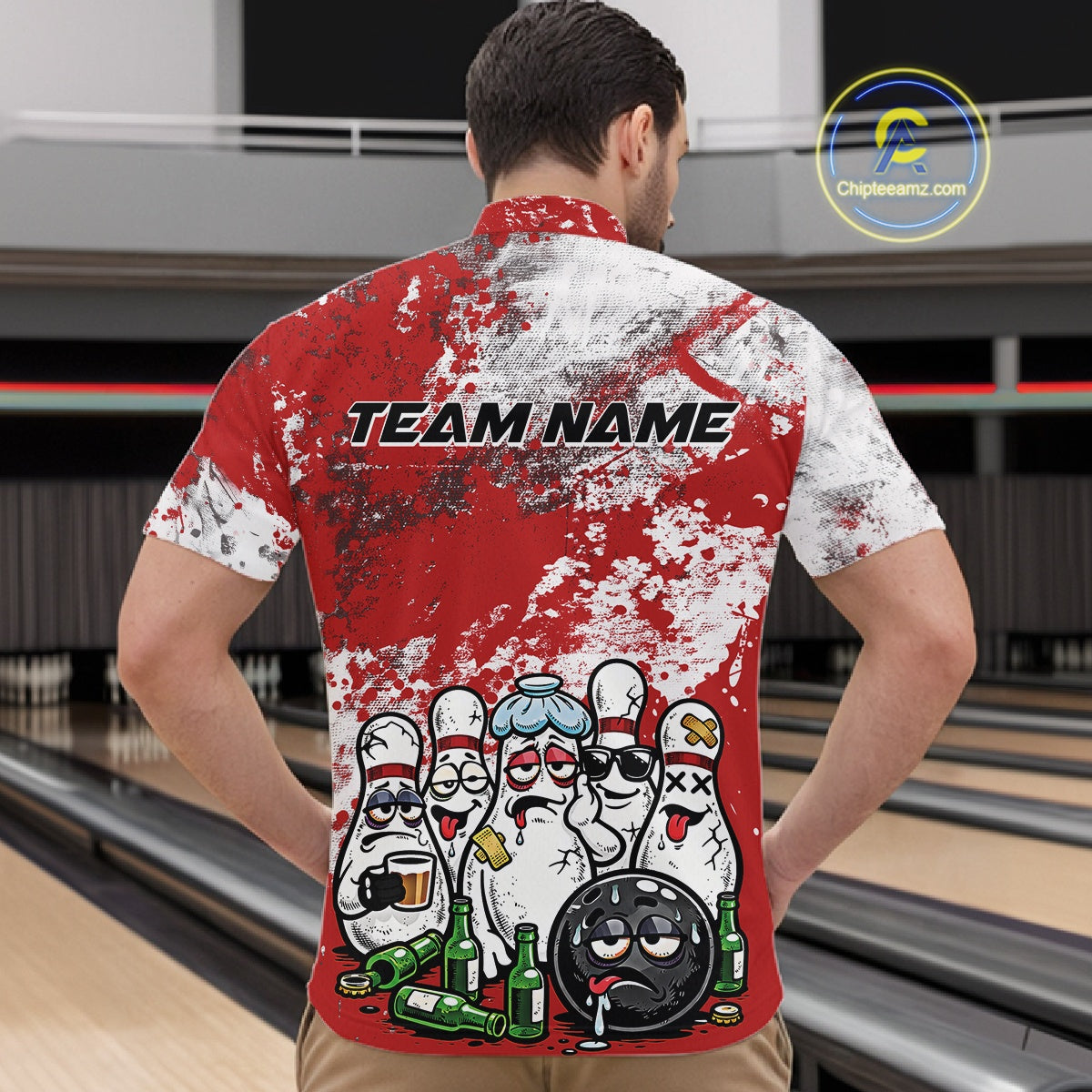 Male model at a bowling lane wearing a quarter zip shirt, front view showcasing red and white splatter design with playful bowling pins and bowling ball illustration