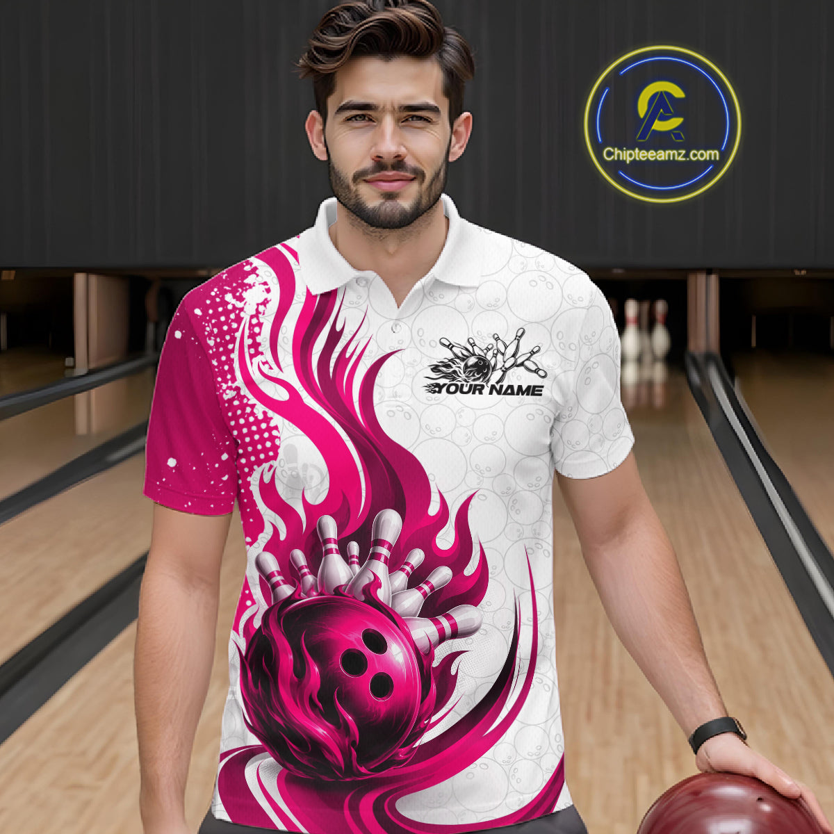 A man wearing a custom bowling polo shirt with a vibrant pink and white flame-and-bowling-ball graphic, standing in a bowling alley. 