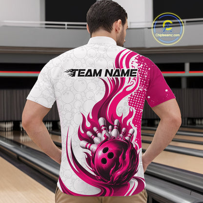 A man viewed from behind wearing a short-sleeve bowling-themed shirt with a white and magenta flame-and-ball graphic, standing in a bowling alley. The shirt has 'TEAM NAME' printed across the upper back