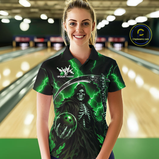 A woman wearing a custom black polo shirt with a green and gray grim reaper graphic, standing in a bowling alley with blurred lanes in the background. 