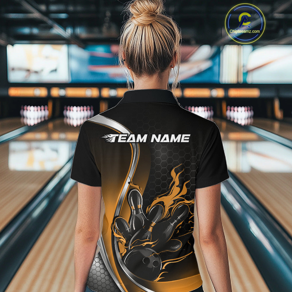 Back view female model in bowling alley wearing black and yellow quarter zip shirt with flame bowling action graphics on fabric