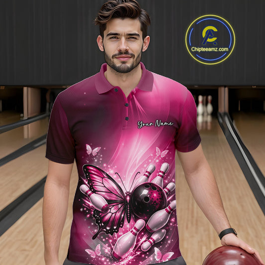 Male model at a bowling lane wearing a pink bowling polo shirt with butterfly artwork, a bowling ball, and scattered pin accents.