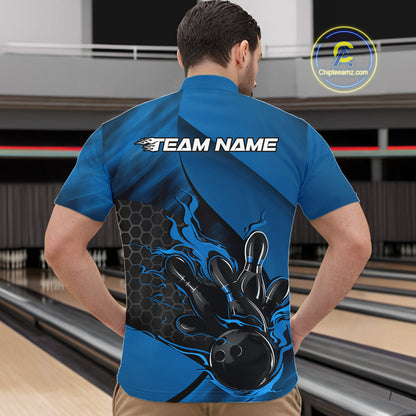 Front view of a male model in a bowling center wearing a black and blue quarter-zip shirt featuring a flaming bowling ball knocking down pins.