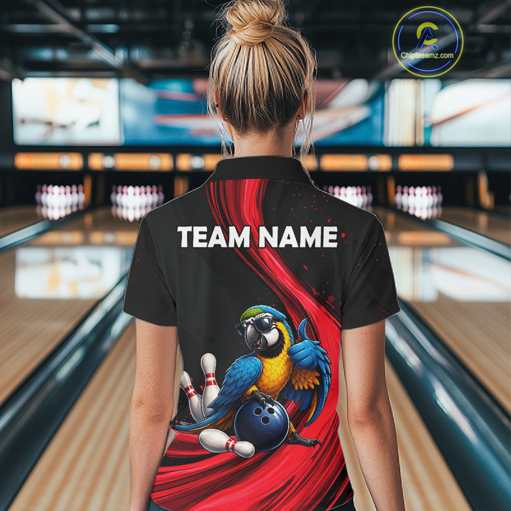 A woman viewed from behind wearing a black short-sleeve bowling-themed polo shirt with a large back graphic showing a blue and yellow macaw, bowling pins, a bowling ball, and red swooshes. The shirt has 'TEAM NAME:' printed in white across the upper back.