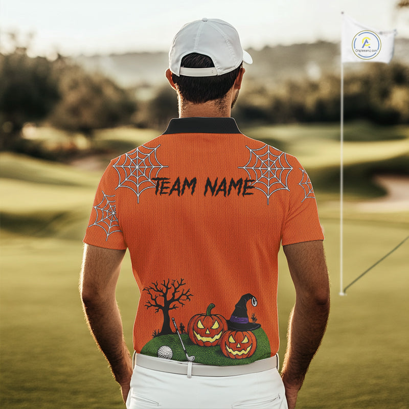 A man viewed from behind wearing an orange custom golf shirt with a white cap, standing on a golf course. The back of the shirt features a black collar, 'TEAM NAME' printed across the upper back, spiderweb graphics on the shoulders, and a Halloween scene with pumpkins, a witch hat, and a tree near the hem.