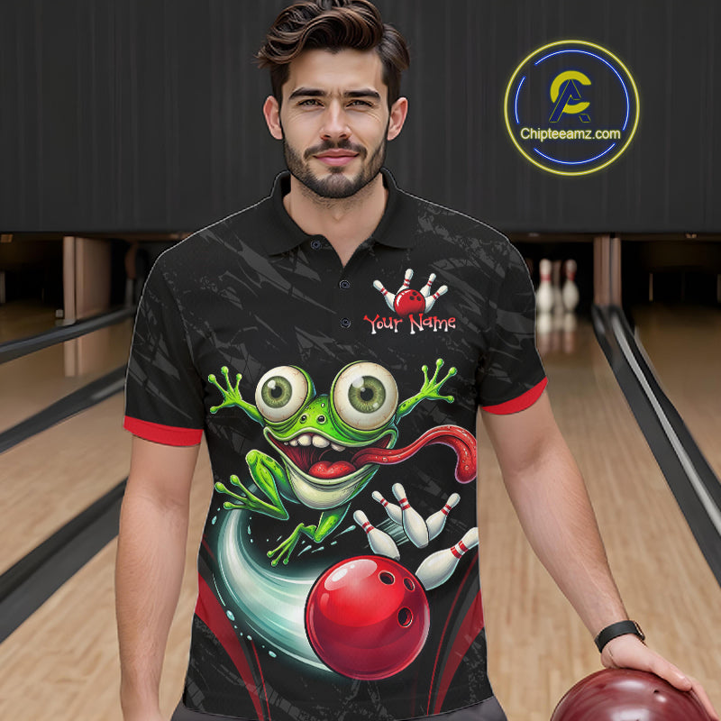 A man in a bowling alley wearing a black short-sleeve polo shirt with a colorful frog and bowling ball graphic on the front, holding a bowling ball. A circular 'Chipleeamz.