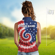 Load image into Gallery viewer, Woman wearing an American flag tie dye womens sleeveless golf polo shirt and 'Team Name' text on the back, standing on a golf course.