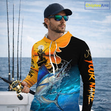 Load image into Gallery viewer, Man wearing a colorful long sleeve hooded fishing shirt with a design of a sailfish fish and a fish reaper, standing on a boat with fishing rods in the background.