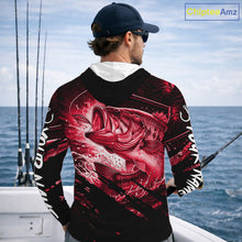 Load image into Gallery viewer, Person wearing a red and black bass hooded fishing shirt with a fish design, standing by the ocean.