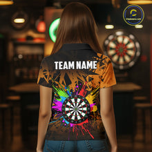 Load image into Gallery viewer, Back view of woman wearing an orange colorful darts jersey inside a darts arena.
