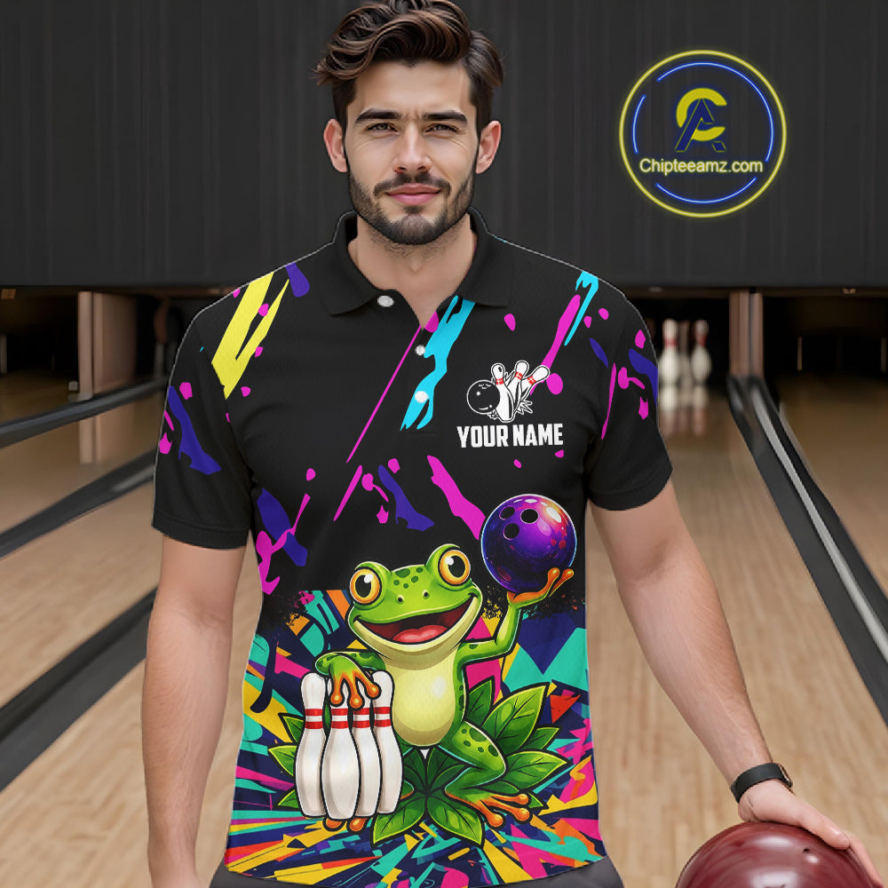 Man wearing a colorful bowling-themed shirt with a frog graphic in a bowling alley.