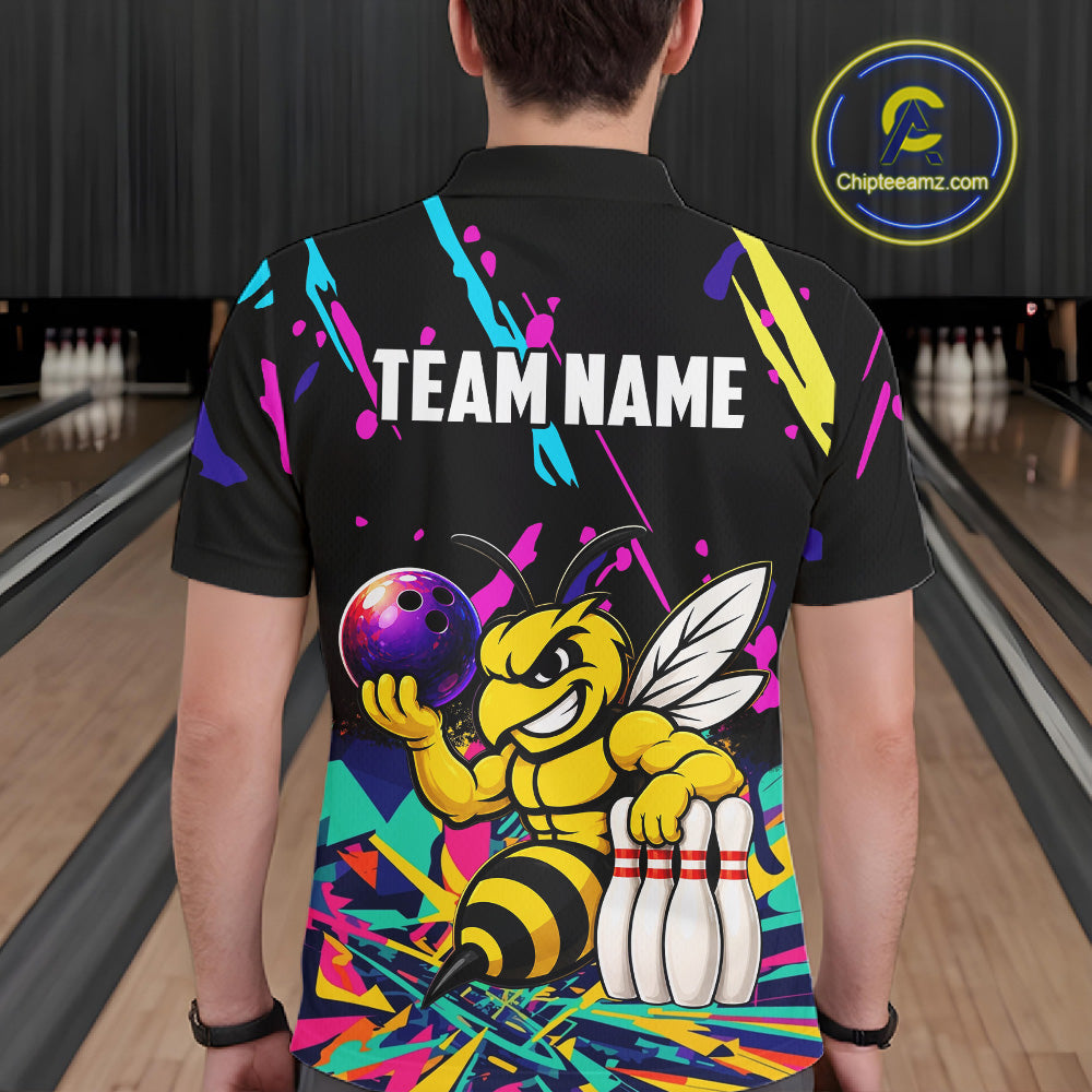 Person wearing a black bowling shirt with colorful design and bee graphic in a bowling alley.