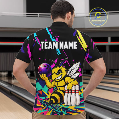 Person wearing a colorful bowling-themed shirt with a bee design in a bowling alley.