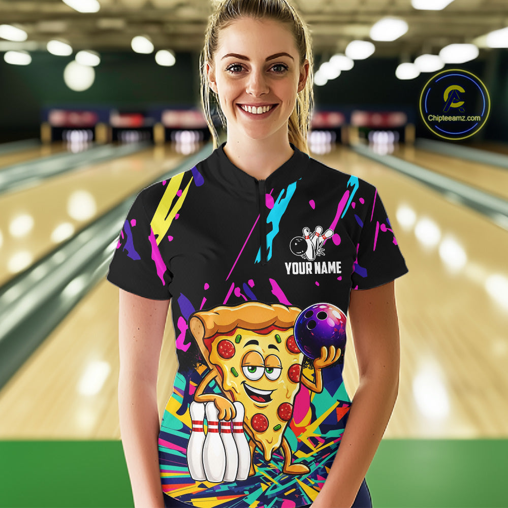 Person wearing a black bowling shirt with colorful design and pizza graphic in a bowling alley.