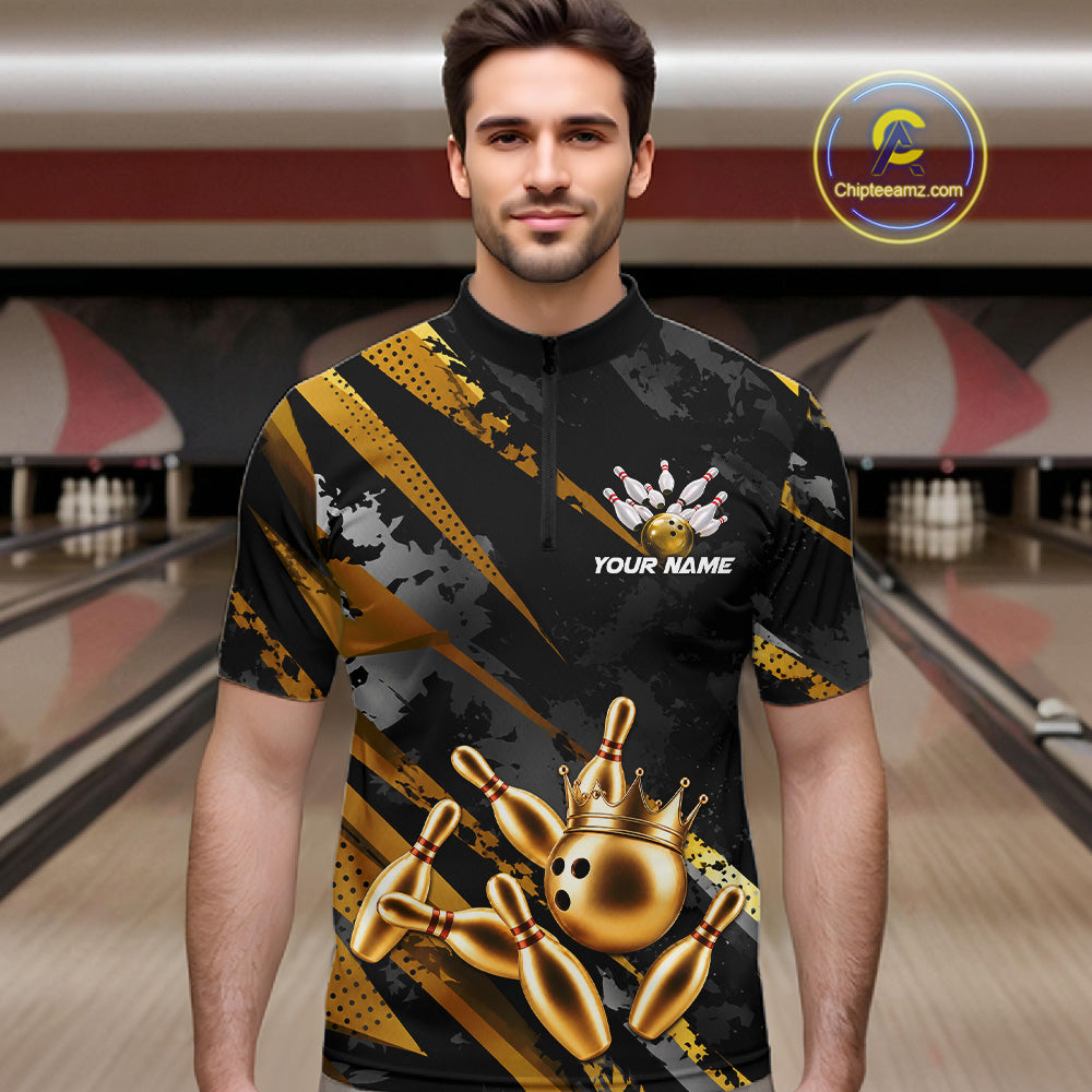 Man wearing a black and gold bowling shirt with a crown design in a bowling alley.