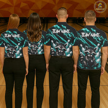 Load image into Gallery viewer, Back view of bowling team wearing matching turquoise neon raccoon bowling shirts in a bowling alley.